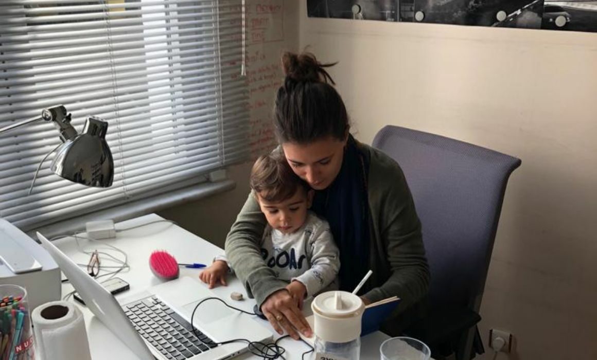 Mère entrepreneure en train de travailler avec son enfant sur les genoux