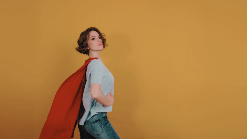 Femme dirigeante en t-shirt porte une cape de super-héroine pour symboliser les super-pouvoirs de la marque